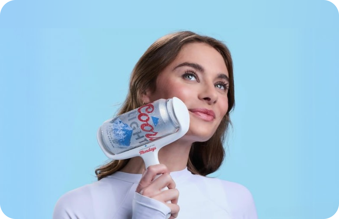A young woman rests a Coors Light branded lint roller against her cheek.
